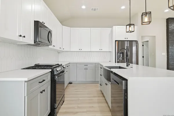a kitchen with stainless steel appliances granite countertop a sink stove and refrigerator