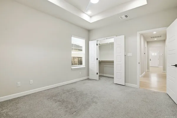 an empty room with windows and cabinet