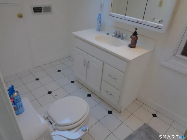 a white toilet sitting next to a bathroom sink