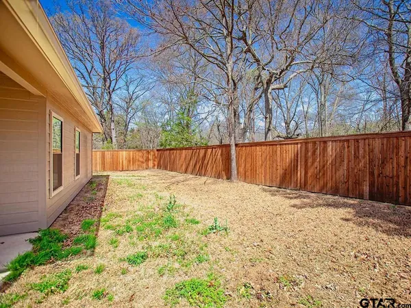 a view of a backyard with wooden fence
