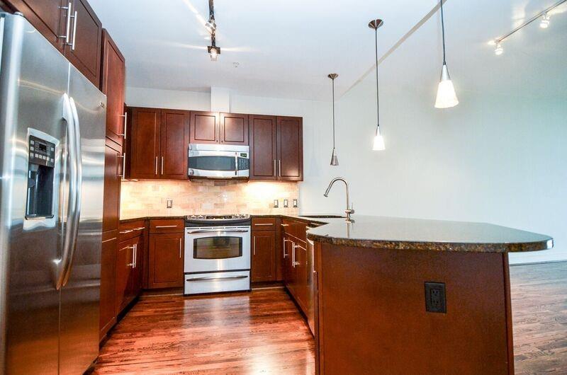 a kitchen with stainless steel appliances granite countertop a sink a stove and kitchen island