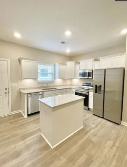 710 Rex Dr Spring Hill Spring Hill, TN 37174 - Photo 3 of 6 a kitchen with stainless steel appliances granite countertop a stove a sink dishwasher a refrigerator and white cabinets with wooden floor