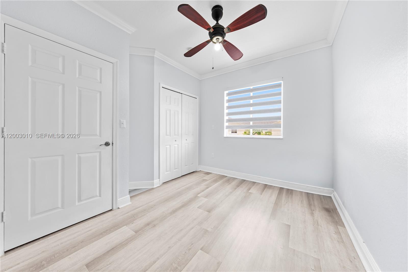 7452 Northwest 178th Street Hialeah, FL 33015 - Photo 18 of 28 an empty room with wooden floor ceiling fan and windows