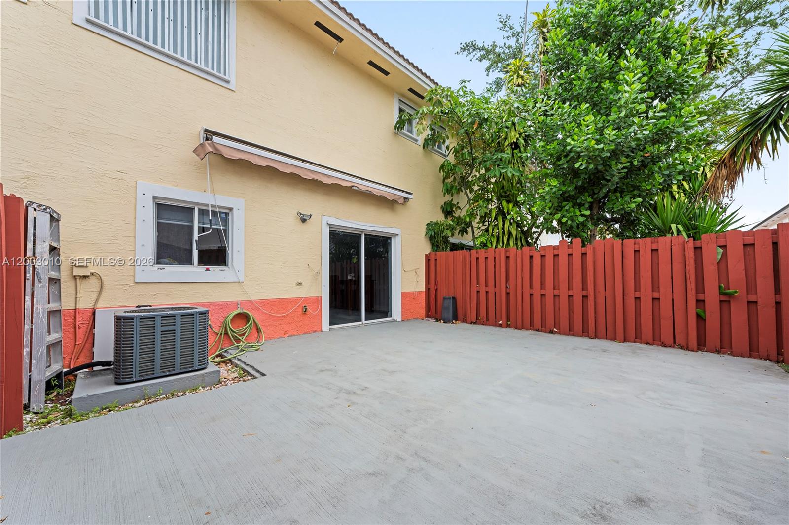 7452 Northwest 178th Street Hialeah, FL 33015 - Photo 20 of 28 a view of a house with wooden fence and large trees