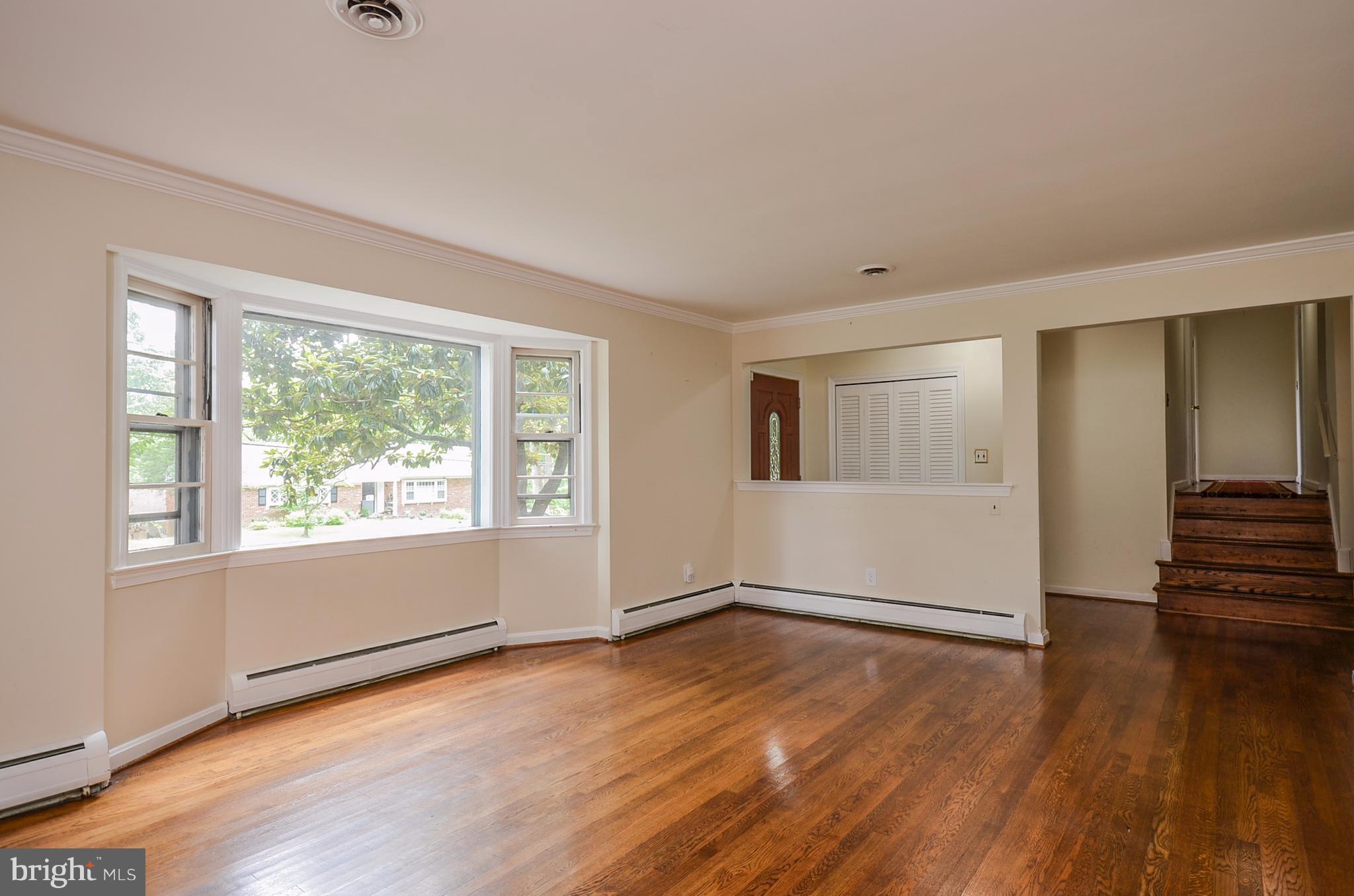 10751 Kinloch Road Silver Spring, MD 20903 - Photo 2 of 30 a view of an empty room with wooden floor and a window