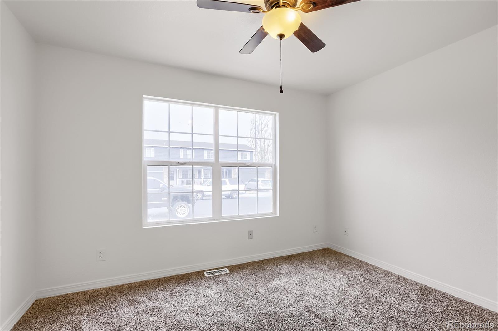3708 Salida Court Evans, CO 80620 - Photo 15 of 19 an empty room with chandelier fan and windows
