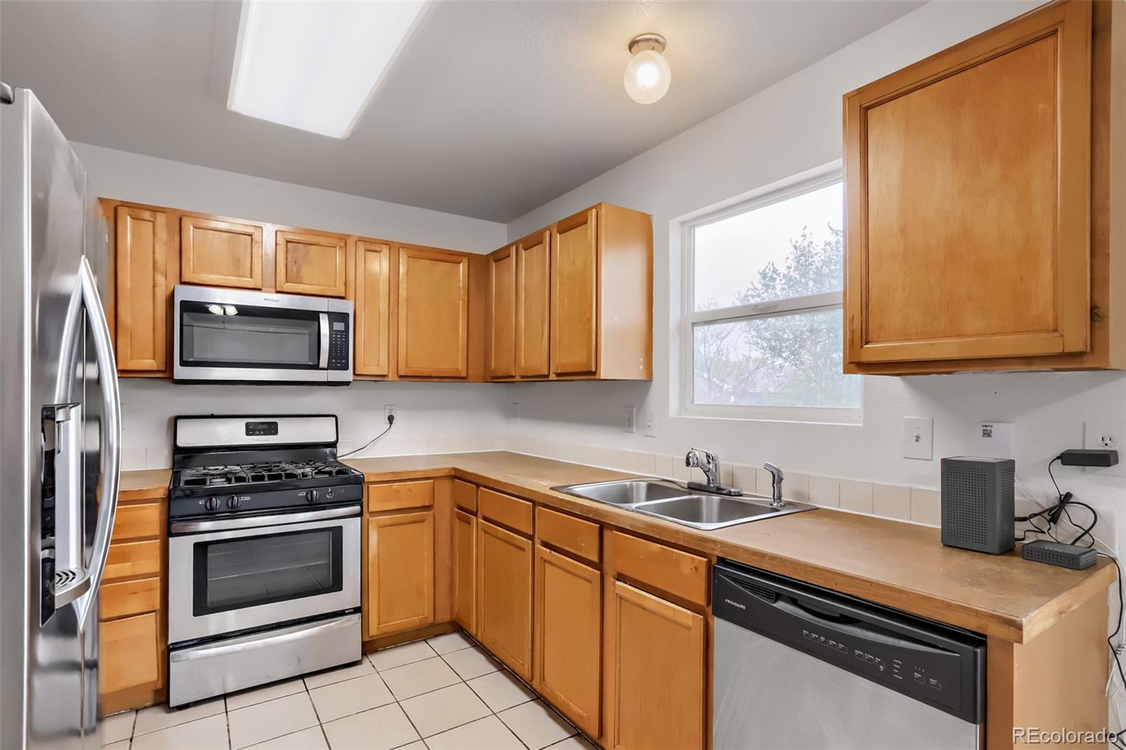 3708 Salida Court Evans, CO 80620 - Photo 9 of 19 a kitchen with granite countertop a stove a sink and a microwave