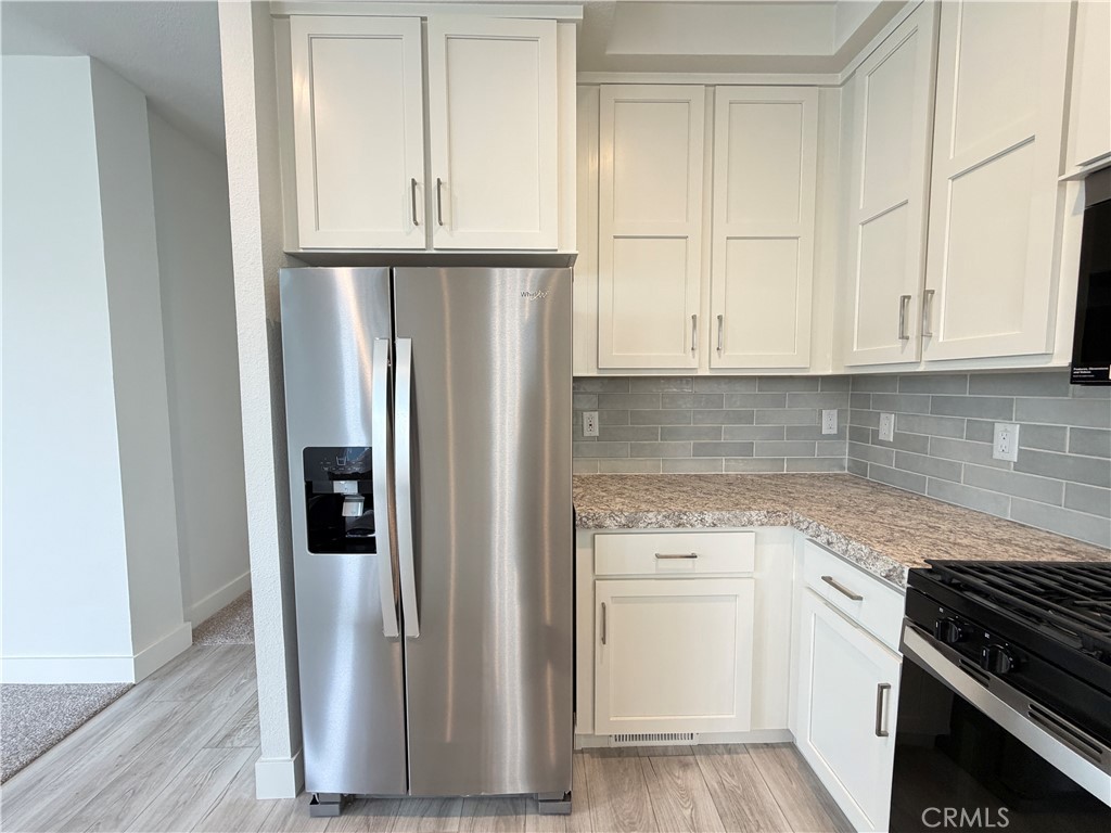 9080 Bloomfield Street, Unit 231 Cypress, CA 90630 - Photo 11 of 20 a kitchen with a white cabinets and refrigerator