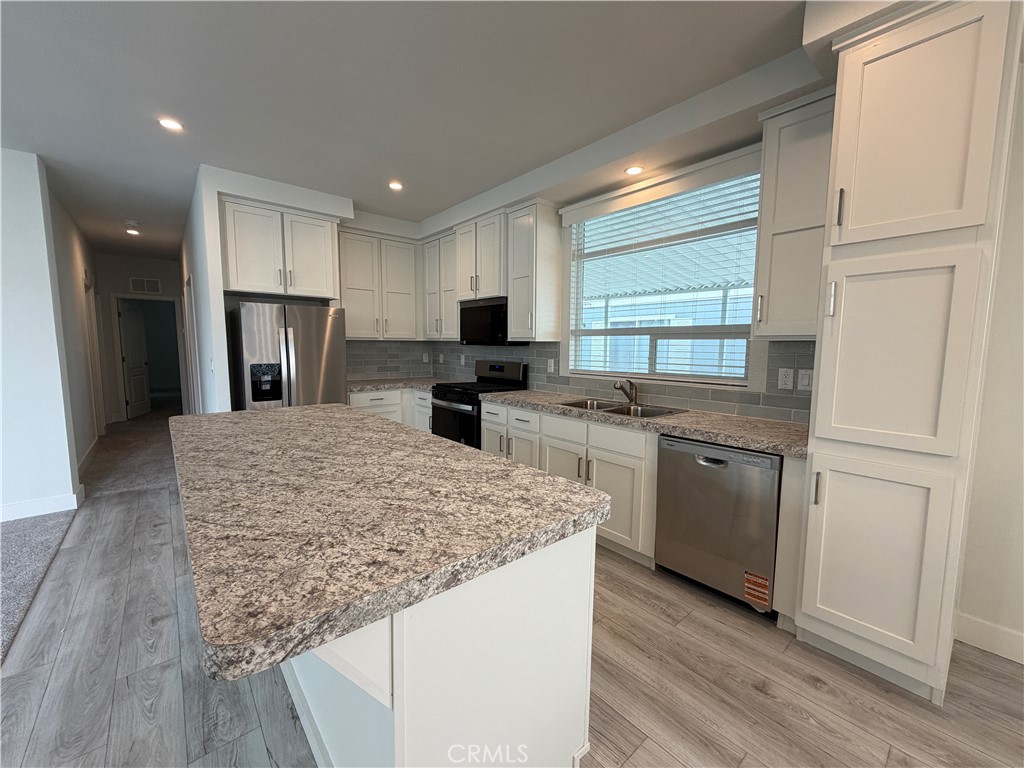 9080 Bloomfield Street, Unit 231 Cypress, CA 90630 - Photo 12 of 20 a kitchen with stainless steel appliances granite countertop refrigerator sink and cabinets