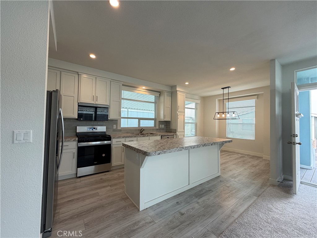 9080 Bloomfield Street, Unit 231 Cypress, CA 90630 - Photo 13 of 20 a kitchen with stainless steel appliances granite countertop a refrigerator and a stove top oven