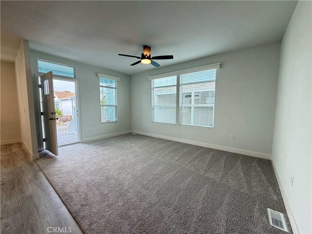 9080 Bloomfield Street, Unit 231 Cypress, CA 90630 - Photo 17 of 20 an empty room with chandelier fan and windows