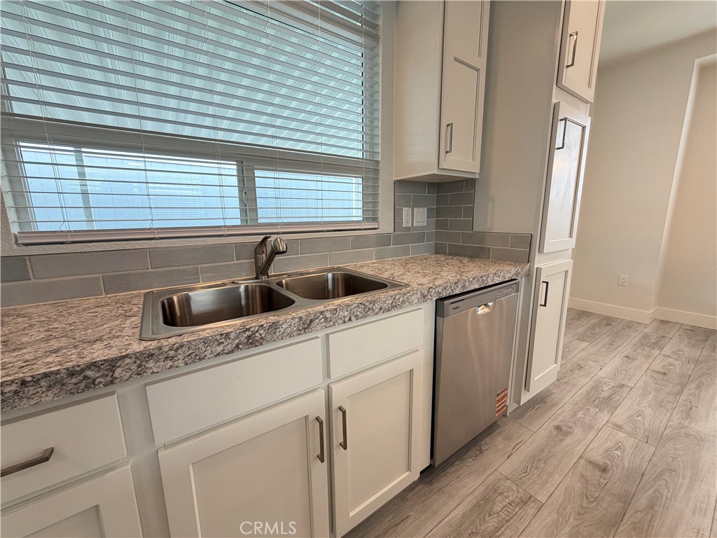 9080 Bloomfield Street, Unit 231 Cypress, CA 90630 - Photo 9 of 20 a kitchen with stainless steel appliances granite countertop a sink and wooden cabinets