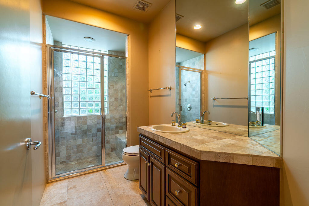 79160 Jack Rabbit Trail La Quinta, CA 92253 - Photo 28 of 48 a bathroom with a granite countertop sink a mirror and a shower
