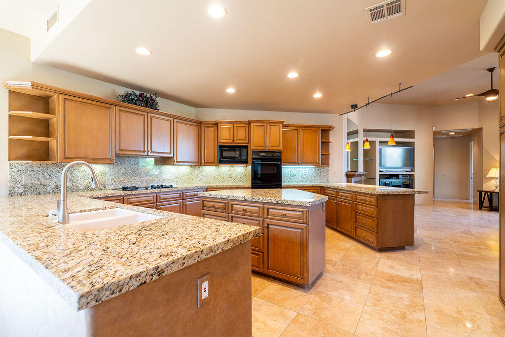 79160 Jack Rabbit Trail La Quinta, CA 92253 - Photo 37 of 48 a kitchen with stainless steel appliances granite countertop a sink counter space and a stove