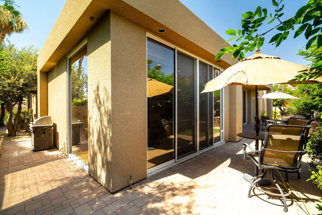 79160 Jack Rabbit Trail La Quinta, CA 92253 - Photo 45 of 48 a patio with a table and chairs under an umbrella