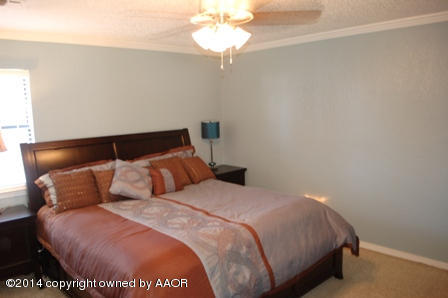 8101 Marni Trail Amarillo, TX 79110 - Photo 21 of 39 a bedroom with a bed and a chandelier