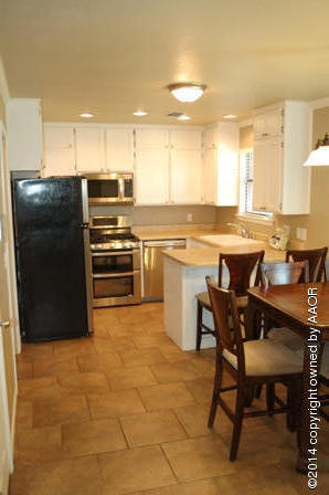 8101 Marni Trail Amarillo, TX 79110 - Photo 27 of 39 a kitchen with stainless steel appliances kitchen island granite countertop a table chairs and a refrigerator