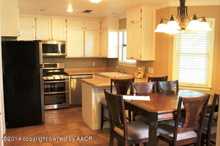 8101 Marni Trail Amarillo, TX 79110 - Photo 28 of 39 a kitchen with stainless steel appliances a dining table chairs and a refrigerator
