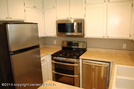 8101 Marni Trail Amarillo, TX 79110 - Photo 31 of 39 a kitchen with stainless steel appliances a refrigerator a stove and a sink with wooden floor