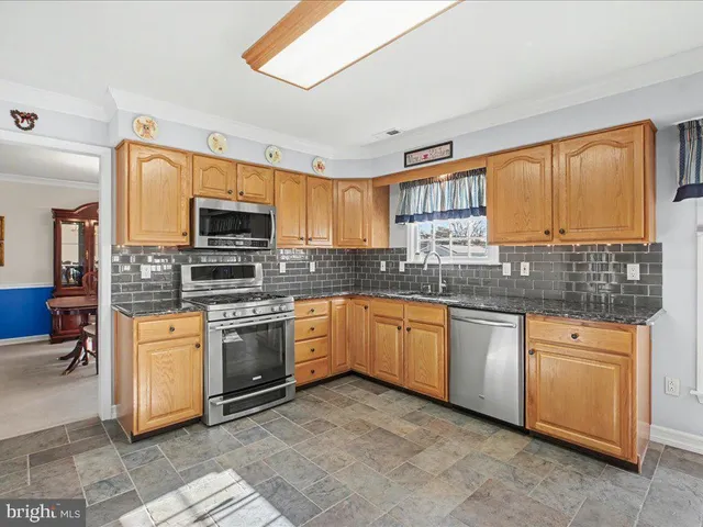 a kitchen with stainless steel appliances granite countertop a stove sink and microwave
