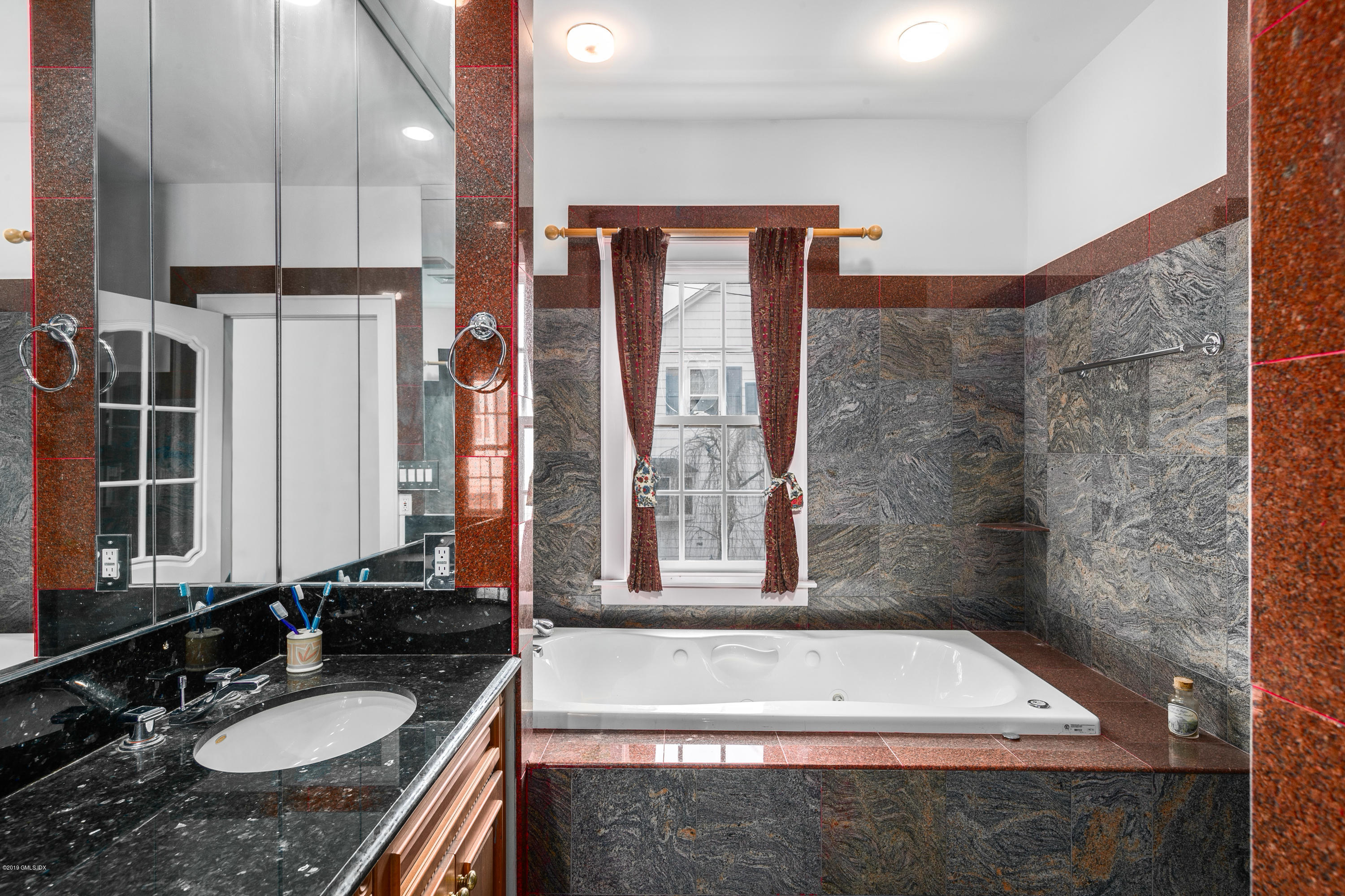 25 Oval Avenue Riverside, CT 06878 - Photo 13 of 18 a bathroom with a granite countertop sink a mirror and a bathtub