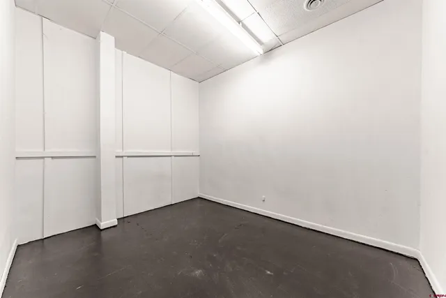 an empty room with wooden floor and white walls