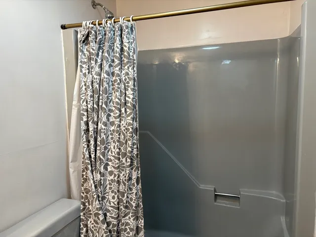 a bathroom with a shower curtain and a shower curtain
