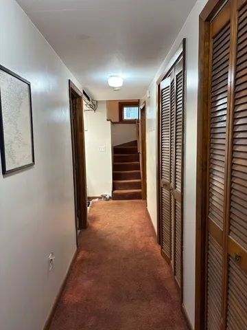 a view of hallway with stairs and furniture