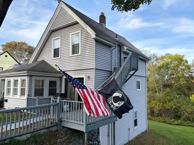 a view of a house with a deck and furniture