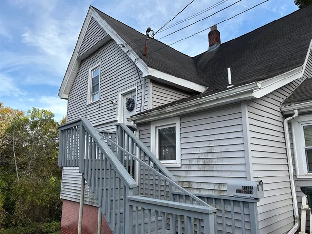 a view of house with wooden stairs and a large tree