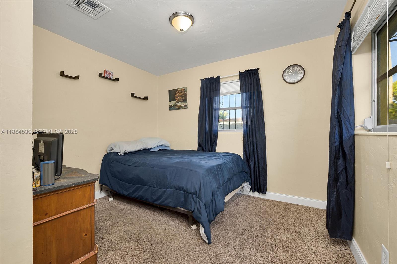 1220 Northwest 88th Street Miami, FL 33147 - Photo 14 of 31 a bedroom with a bed and a flat tv screen on dresser