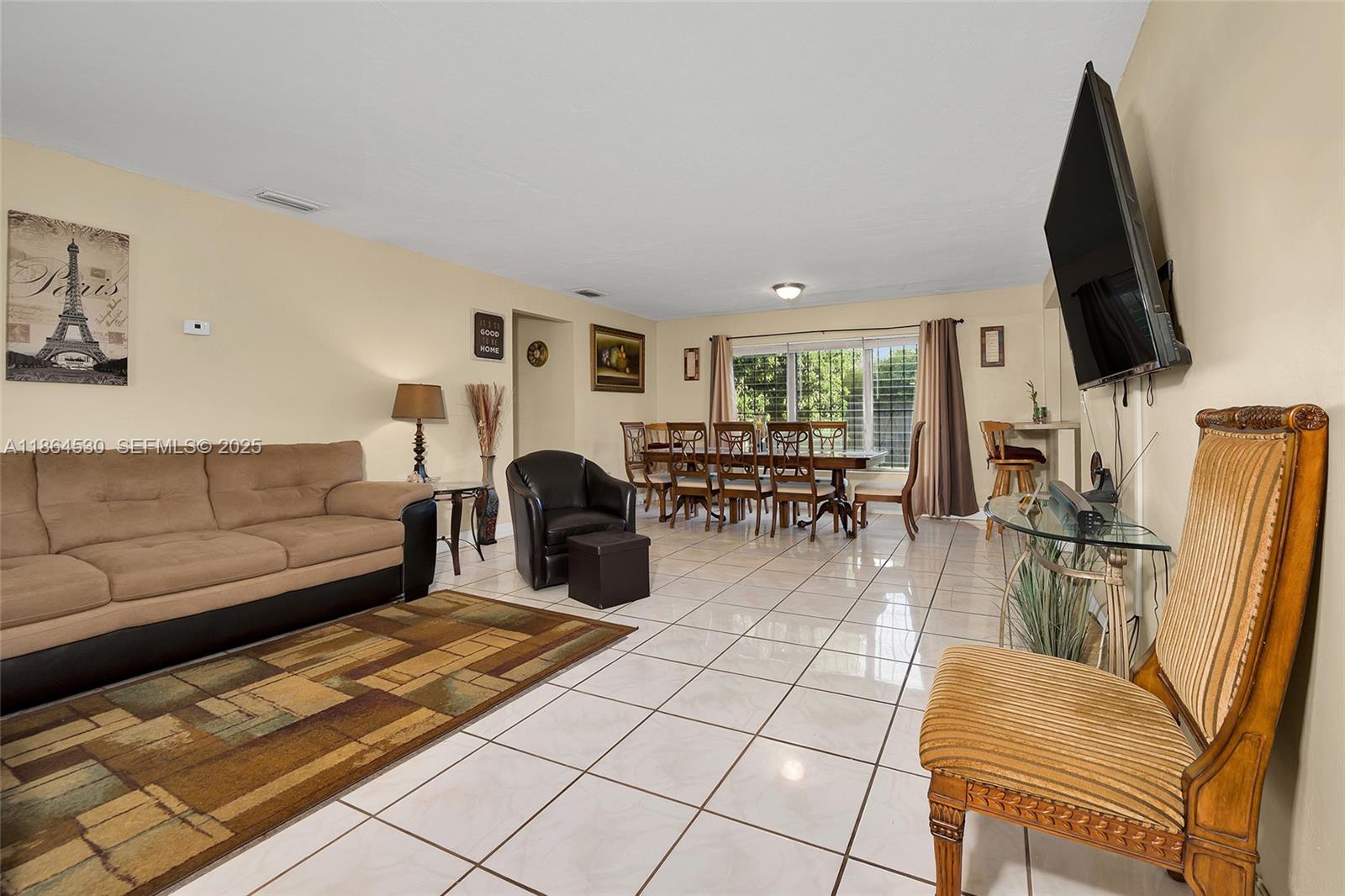 1220 Northwest 88th Street Miami, FL 33147 - Photo 6 of 31 a living room with furniture a flat screen tv and a table