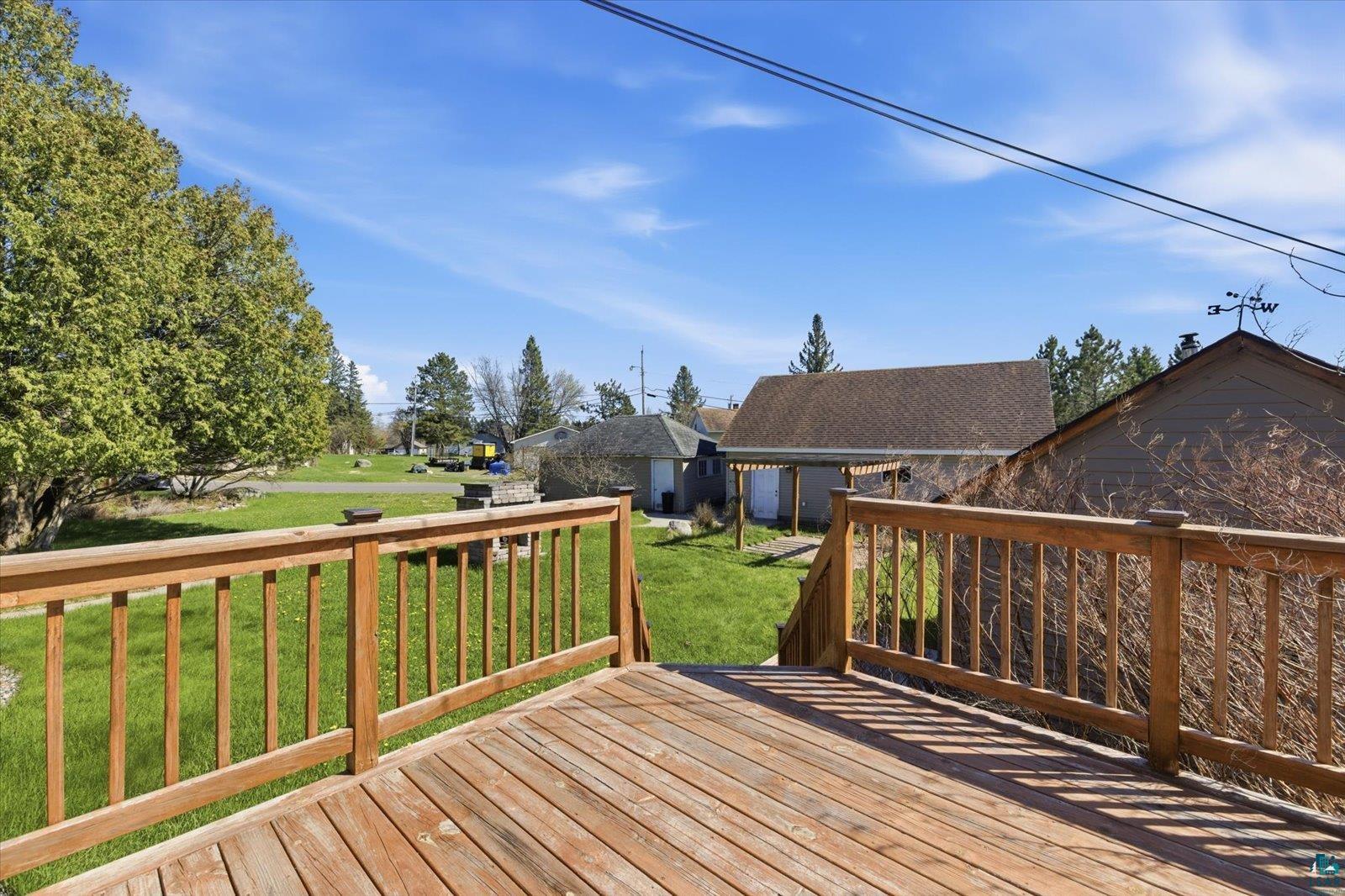 50 Main Street Soudan, MN 55782 - Photo 13 of 31 Expansive wooden deck with natural wood railing, offering a broad perspective of the property's exterior