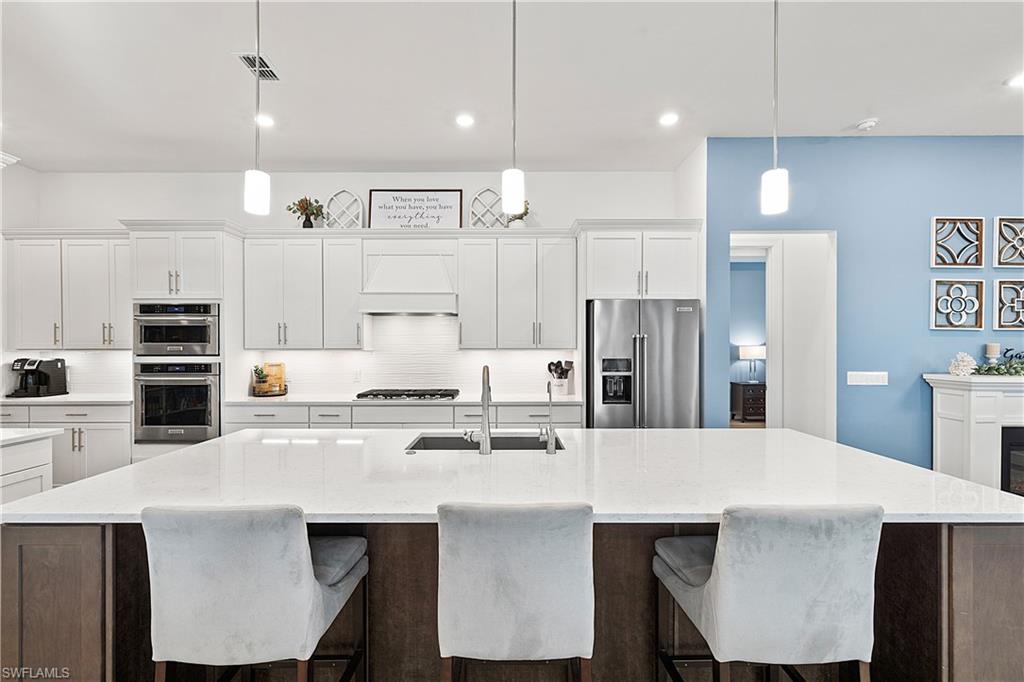 20549 Napa Loop Estero, FL 33928 - Photo 10 of 50 a kitchen with stainless steel appliances a table chairs refrigerator and stove