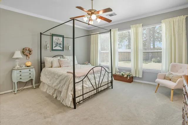 a spacious bedroom with a bed and a chandelier