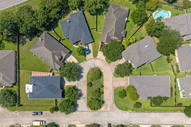 an aerial view of a house with garden space and a car parked