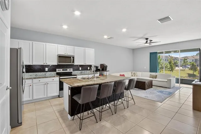 a kitchen with a sink dining table and chairs
