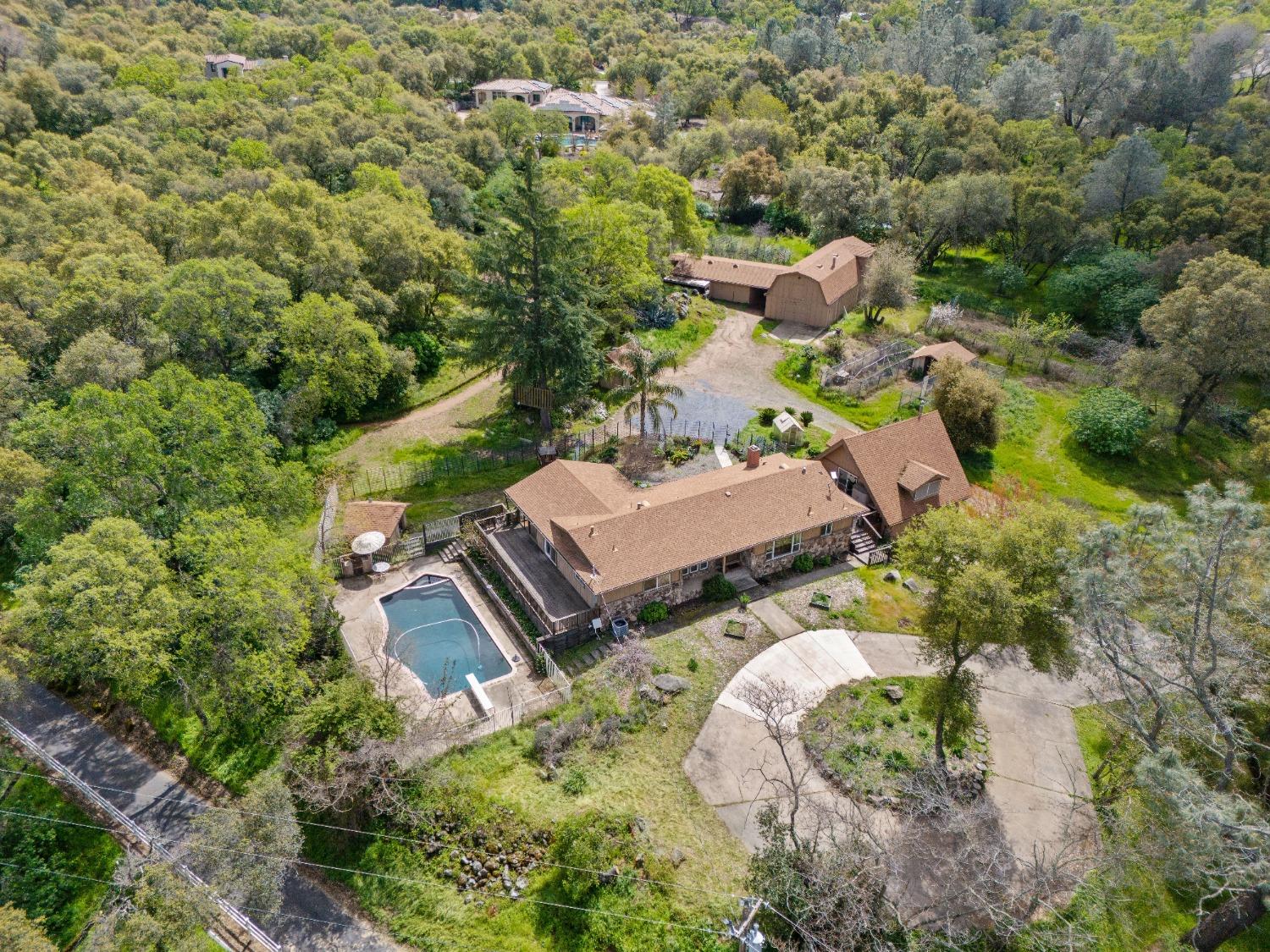 an aerial view of a house with a yard and large trees