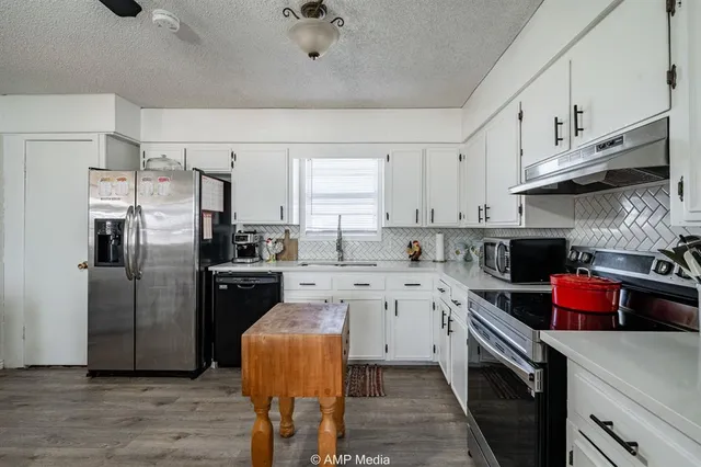 a kitchen with stainless steel appliances a stove refrigerator sink and cabinets