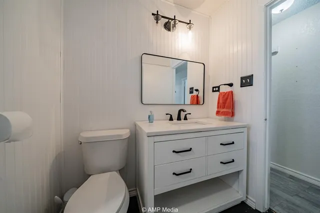 a bathroom with a toilet sink and mirror