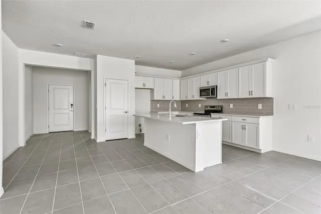 a kitchen with white cabinets and white appliances