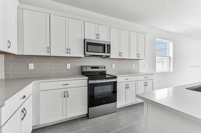 a kitchen with white cabinets and a stove top oven