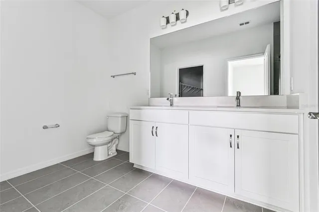 a bathroom with a granite countertop sink mirror vanity and toilet