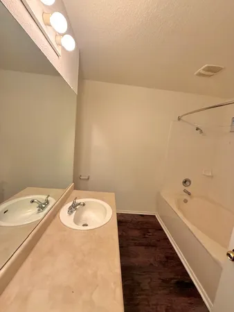 a bathroom with a tub sink and vanity