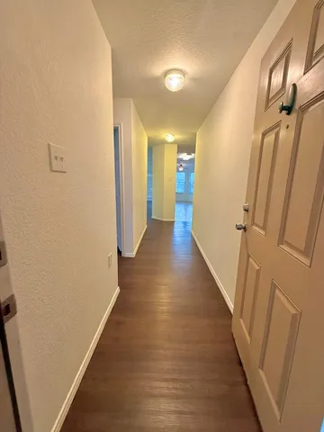 a view of a hallway with wooden floor