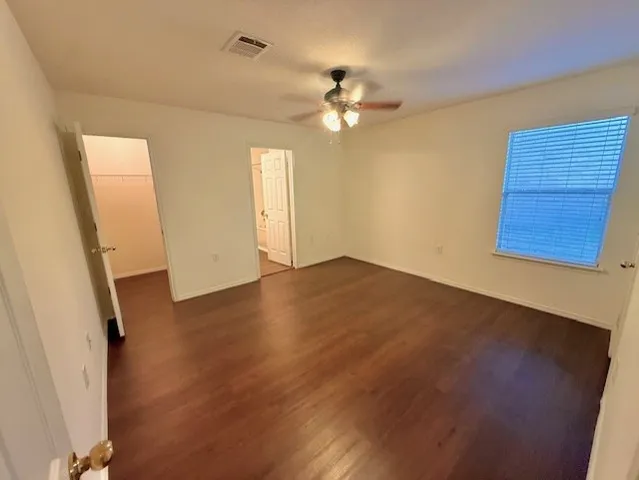a view of a livingroom with wooden floor and a ceiling fan