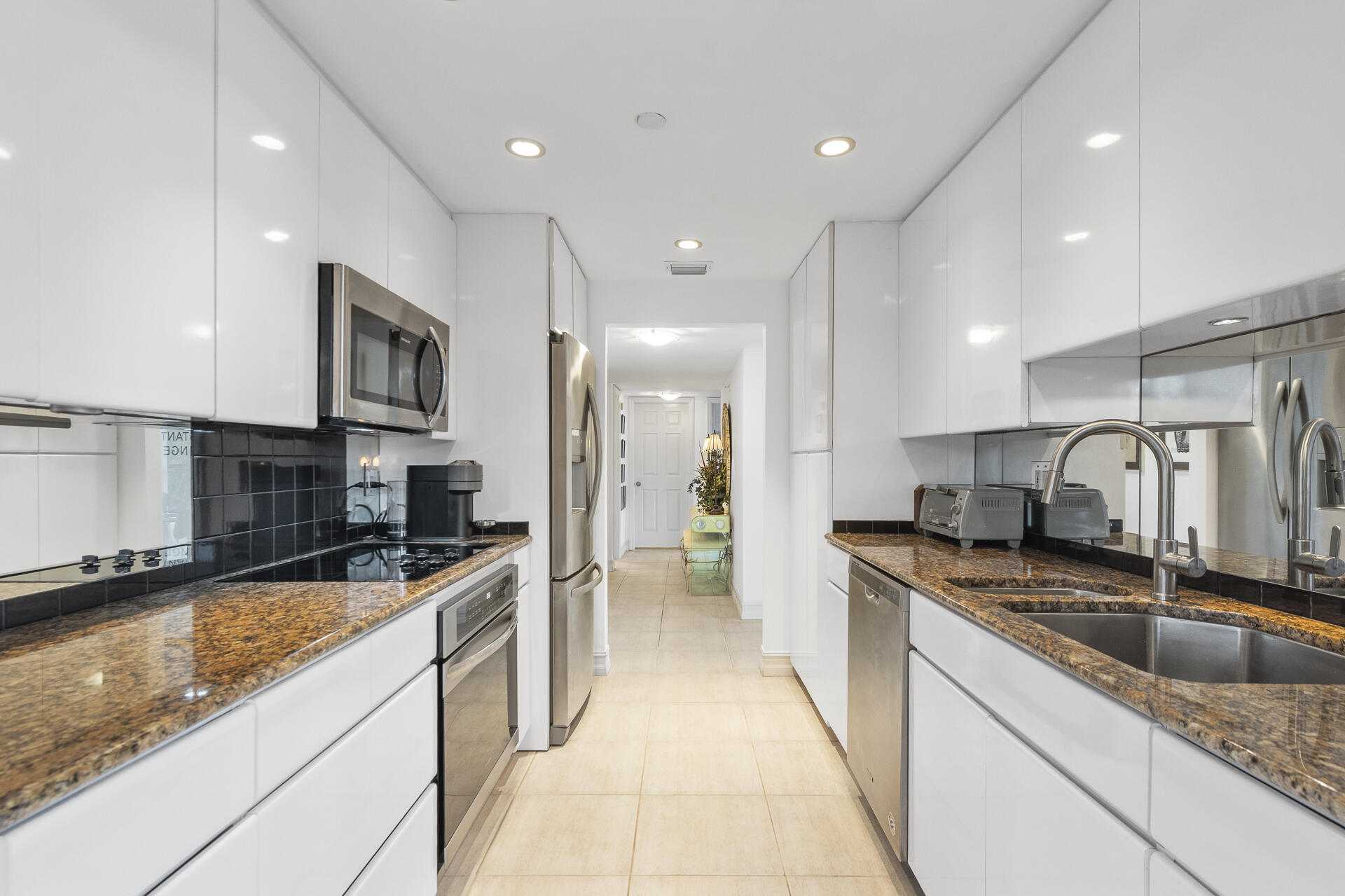 a modern kitchen with stainless steel appliances granite countertop a sink a stove and a refrigerator
