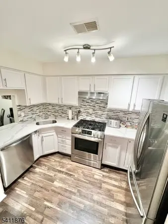 a kitchen with stainless steel appliances granite countertop a stove a sink and a refrigerator
