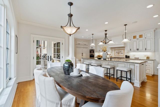 a kitchen with stainless steel appliances granite countertop a table chairs and a refrigerator