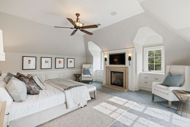 a spacious bedroom with a large bed and a fireplace